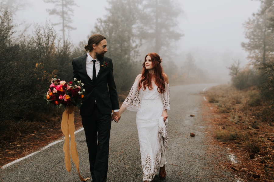 bride and groom walking through the fog with a fall color palette. fall floral inspiration